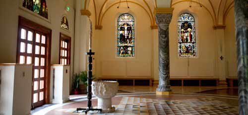 A photo of the baptismal font an paschal candle just inside the entrance to the Archabbey Church.