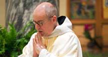 A photo of a monk praying at Mass.